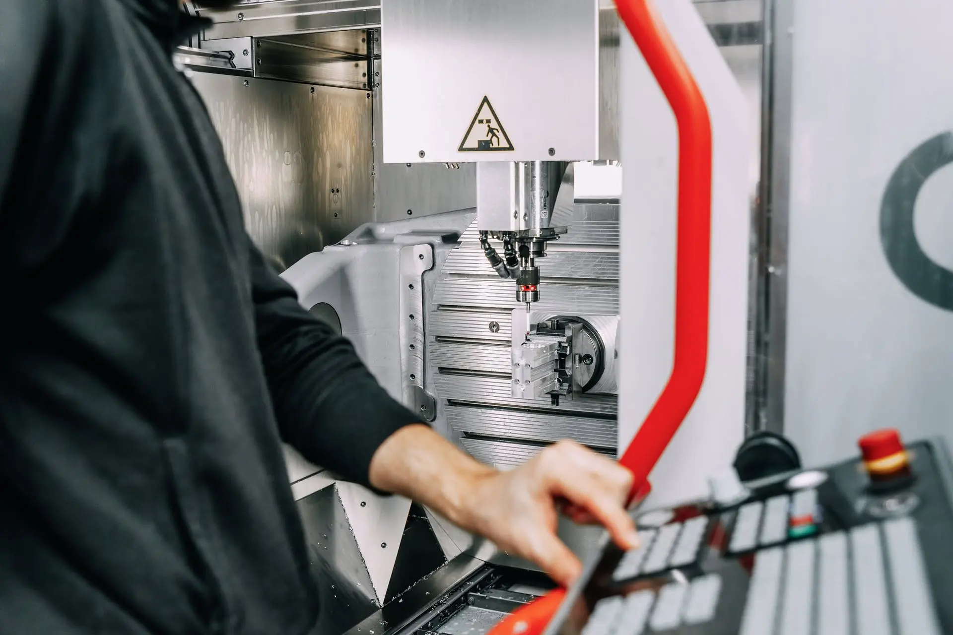 Bediener an einer CNC-Fräsmaschine während der Bearbeitung
